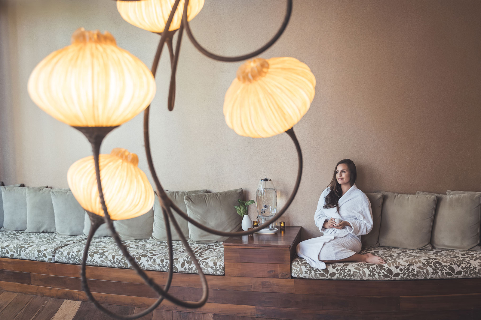 Gwinganna-095 A serene bathroom interior featuring a modern white bathtub next to large glass windows overlooking a lush green forest with a hanging chair and wooden deck.