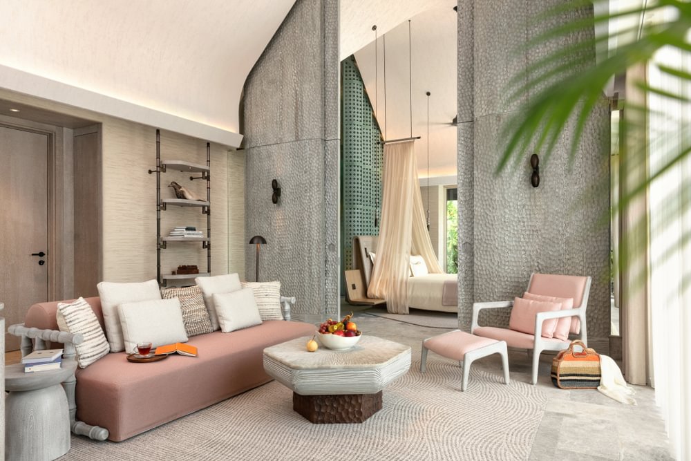 A person in a red life vest riding a blue and black jet ski across choppy ocean waves, creating splashes and a wake behind the watercraft.